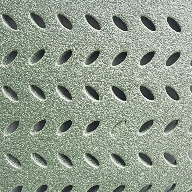 Close-up of green textured perforated grating with rows of oval holes.