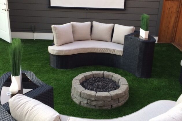Heavy lawn furniture and fire pit sitting on top of artificial grass