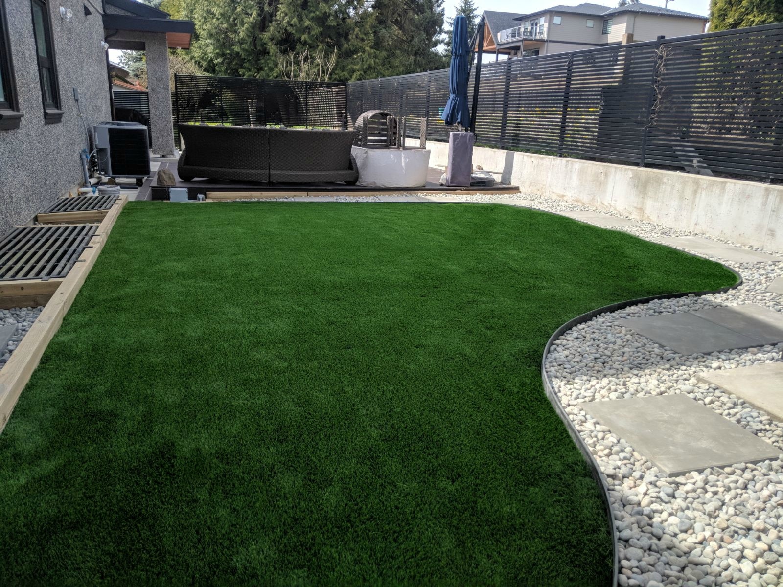 Custom Installation Synthetic Turf with River Rock and Pavers in Port Coquitlam, BC